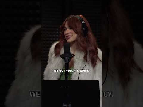 Dua Lipa in headphones at a studio microphone in SNL’s Young Spicy sketch